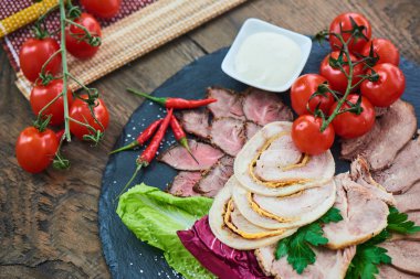 Biftek pişmiş jambon ve tavuk rulo sığır dilini ve taş tahtaya hizmet domates ile