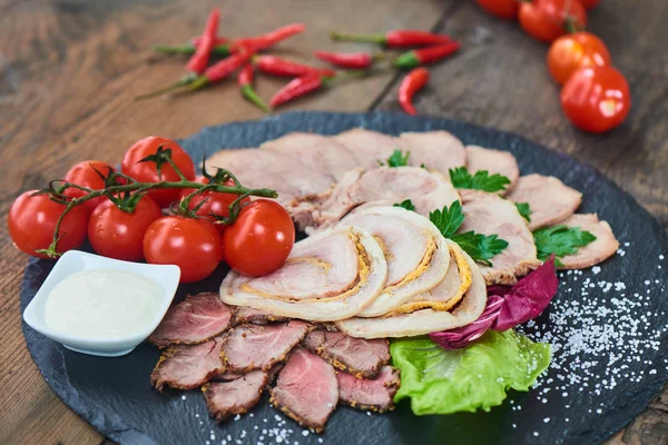 Biftek pişmiş jambon ve tavuk rulo sığır dilini ve taş tahtaya hizmet domates ile