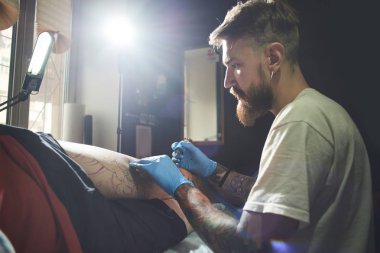 yatak ve onu karanlık atölyede dövme dövmeci yatan istemci