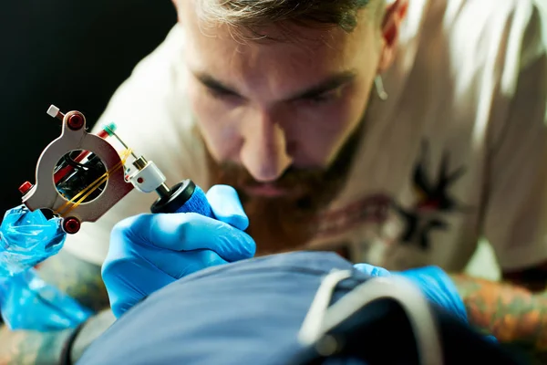 Genç esmer adam dövme ana istemci tarafından dövme Dövme yapma makine, yakın çekim