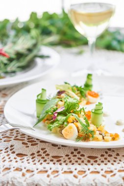 Beyaz tabak bardak beyaz şarap, ile hizmet veren geleneksel olivier salata yakın çekim