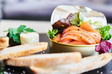 taş masa, teneke ve gevrek baget dilimleri içinde somon yakın çekim