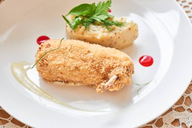 Kiev tavuğu kırıntıları parmesan soslu kızarmış ve beyaz tabakta dijon hardal ile patates püresi