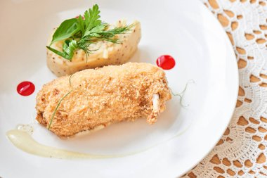 Kiev tavuğu kırıntıları parmesan soslu kızarmış ve beyaz tabakta dijon hardal ile patates püresi