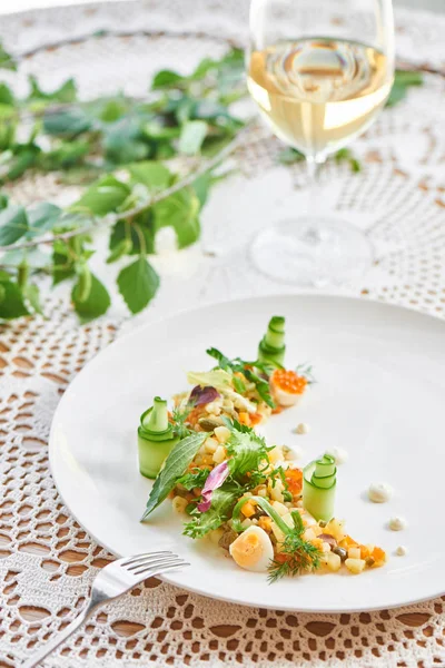 Beyaz tabak bardak beyaz şarap, ile hizmet veren geleneksel olivier salata yakın çekim