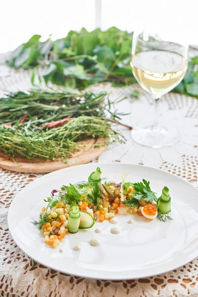 Beyaz tabak ve bardak beyaz şarap tablo, hizmet veren geleneksel olivier salata yakın çekim