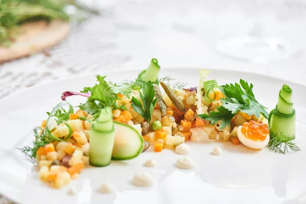 Beyaz plaka üzerinde hizmet veren geleneksel olivier salata yakın çekim