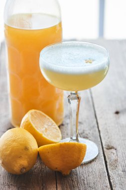 Şarap cam ve ahşap masa şişesinde alkollü kokteyl Limoncello sauer servis