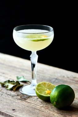 Alkollü kokteyl ROM ve limonlu kokteyl bardak ve limes siyah arka plan ile ahşap tablo