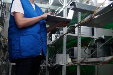 Madencilik. Kripto birimlerinin çıkarılması için bir çiftlikte çalışan bir adam. Bitcoin iş