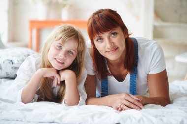 Ana yatak odası, Aile zaman kavramı yatakta yatan ise kameraya bakarak ile mutlu kızı  