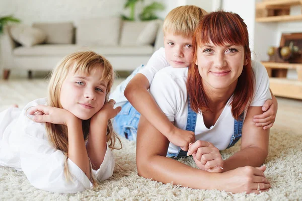母と娘と息子の自宅のカーペットの上には 一緒に横になっています — ストック写真