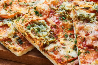 Geleneksel pizza jambon, peynir ve domates ile Yeşiller closeup ile serpilir