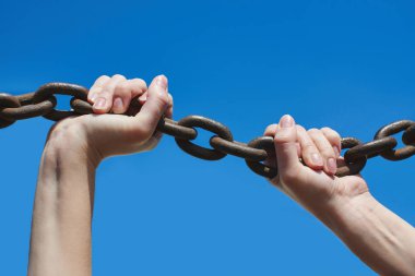 Kadının ellerini demir zinciri bir mavi arka planı portre üzerinde tutun.