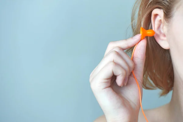 Blondes Mädchen Steckt Ohrstöpsel Ins Ohr Auf Weißem Hintergrund — Stockfoto