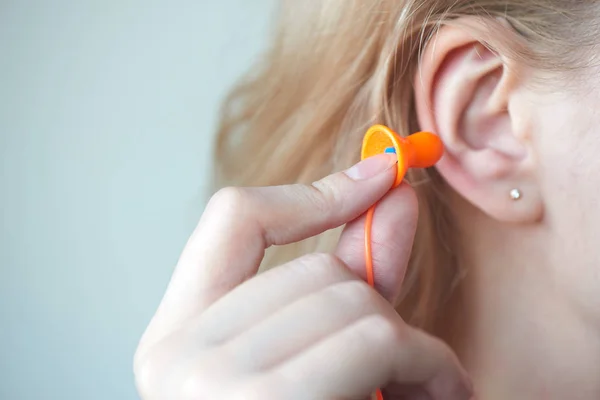 Ξανθό Κορίτσι Βάζει Earplug Στο Αυτί Λευκό Φόντο — Φωτογραφία Αρχείου