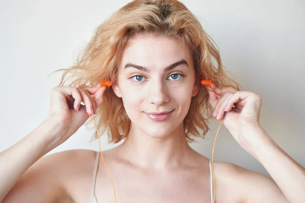 Blondes Mädchen Steckt Ohrstöpsel Die Ohren Auf Weißem Hintergrund — Stockfoto