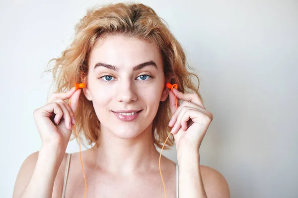 Blondes Mädchen Steckt Ohrstöpsel Die Ohren Auf Weißem Hintergrund — Stockfoto