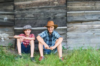 Köyde çimenlerin üzerinde gülümseyen iki kardeş otur