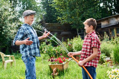 Kardeşler birbirlerini köyün su sıçramasına eğleniyor