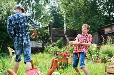 Kardeşler birbirlerini köyün su sıçramasına eğleniyor