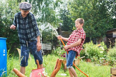 Kardeşler birbirlerini köyün su sıçramasına eğleniyor