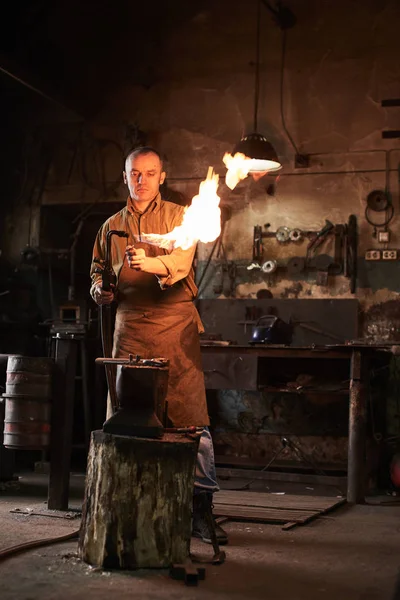 鍛冶屋は アンビルの金属製品をガス バーナーを加熱します — ストック写真