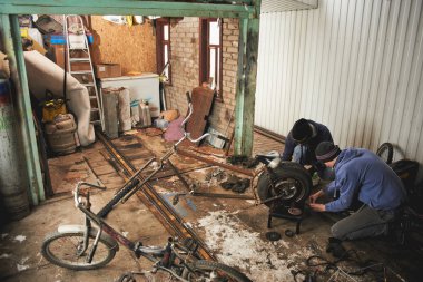 Garajda çalışırken bisiklet parçaları sabitleme erkekler