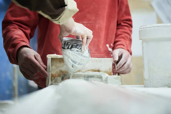 Cropped view of master in the production process of gypsum products