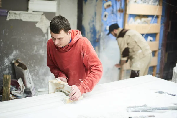 Team of professional sculptors working on gypsum decorations