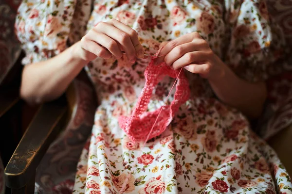 ピンクのウール トップ ビューで編み物女性の手のクローズ アップ表示 — ストック写真
