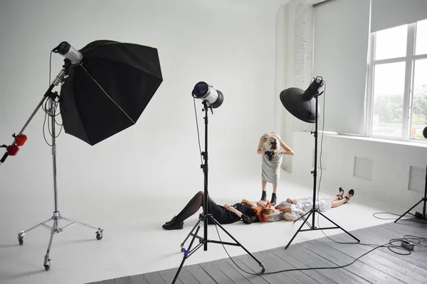 顔やスタジオで白の床の上に横たわる黒服にザクロ マスクとクリアコートのファッションモデルを撮影の女の子の写真 — ストック写真