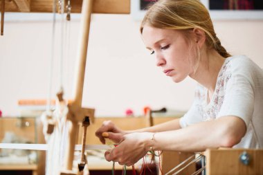 kadın Tekstil dokuma tezgahı üzerinde el yapımı üretim sürecinde 