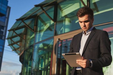 yakışıklı işadamı elbiseli Caddesinde duran tablet PC'yi kullanma 