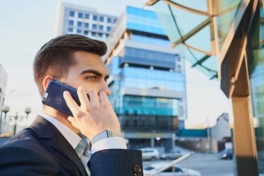 işadamı uymak Smartphone'da Caddesi'nde yürürken yan görünüm 
