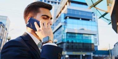 işadamı uymak Smartphone'da Caddesi'nde yürürken yan görünüm 