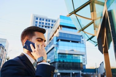 işadamı uymak Smartphone'da Caddesi'nde yürürken yan görünüm 