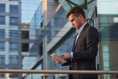 yakışıklı işadamı elbiseli Caddesinde duran tablet PC'yi kullanma 