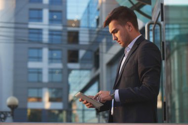 yakışıklı işadamı elbiseli Caddesinde duran tablet PC'yi kullanma 