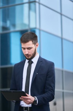 işadamı tablet pc el arka plan üzerinde Mimari camlar ile arıyorum. 