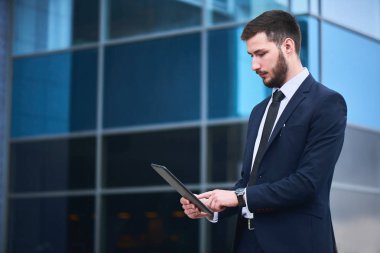 işadamı tablet pc el arka plan üzerinde Mimari camlar ile arıyorum. 