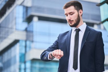 yakışıklı işadamı yandan şehir merkezinde dururken bakarak 