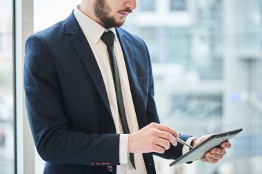 ekran kalemi pan tutarak ve ofis, penceresinde yakın dururken tablet pc kullanarak iş adamı yakın çekim 