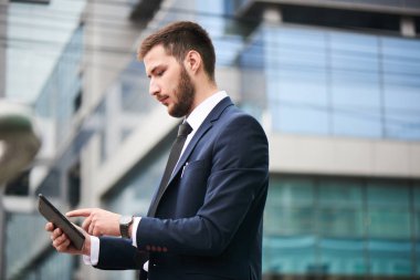 yakışıklı işadamı elbiseli Caddesinde duran tablet PC'yi kullanma 