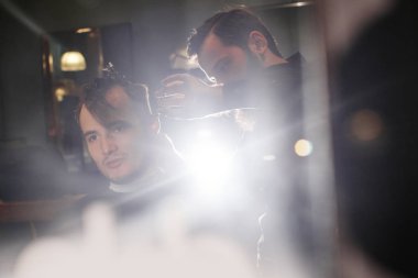 Kuaför müşteri berber dükkanı olarak kesme sürecinde siyah tişörtlü adam