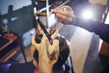 Kuaför müşteri berber dükkanı olarak kesme sürecinde siyah tişörtlü adam