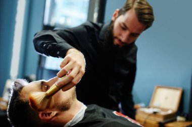 Kuaför müşteri berber dükkanı olarak kesme sürecinde siyah tişörtlü adam