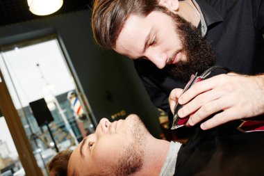 Kuaför müşteri berber dükkanı olarak kesme sürecinde siyah tişörtlü adam