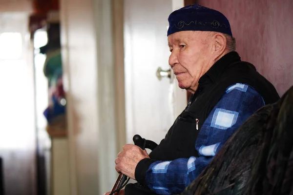 在哈萨克斯坦的房子里坐着手杖的亚洲男人 — 图库照片