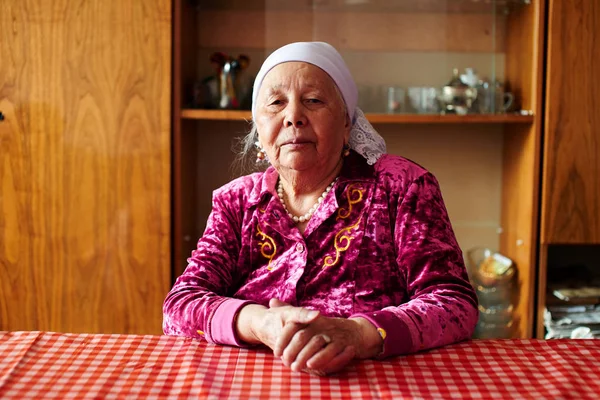 Portrét Starého Kazašského Ženy Při Pohledu Fotoaparát Při Sezení Stolu — Stock fotografie